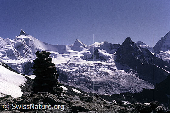 Foto: Zinalrothorn, Obergalbelhorn, Blanc de Moming und Besso. Im Vordergrund ein Steinmann und die Gletscherlandschaft des Glacier de Moming. Aufnahme ab Dia.