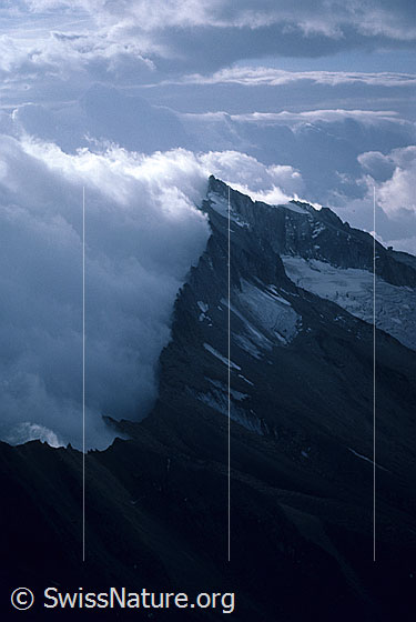 Foto: Blick vom Gipfel des Weissmies zum Portjengrat mit eindrücklicher Wolkenstimmung. Aufnahme ab Dia.