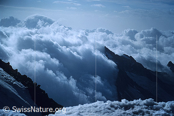 Foto: Blick vom Gipfel des Weissmies zum Portjengrat. Mit eindrücklicher Wolkenstimmung. Aufnahme ab Dia.