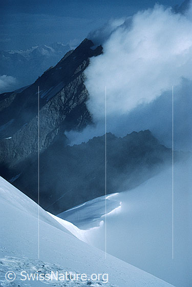 Foto: Blick vom Gipfel des Weissmies zum Lagginhorn. Mit eindrücklicher Wolkenstimmung. Aufnahme ab Dia.