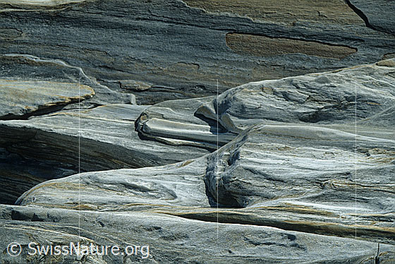 Foto: Vom Wasser geschliffener Fels am Ufer der Verzasca, Tessin. Der Fels ist mehrfarbig und weist eine interessante Struktur auf.