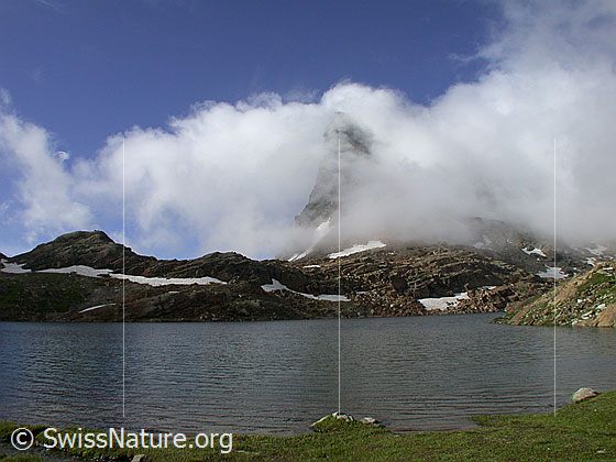 Foto: Geisspfadsee mit Geisspfad. Hinter Nebelschwaden ist das Rothorn erkennbar.