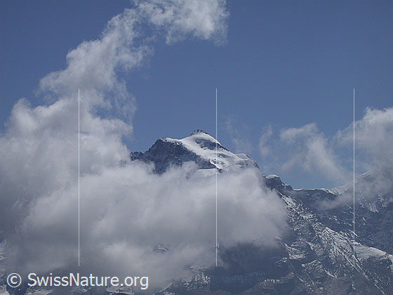 Foto: Gipfel der Jungfrau von NW (Sattel 2674 unterhalb Schwalmere). Der Gipfel ist von Wolken umgeben.