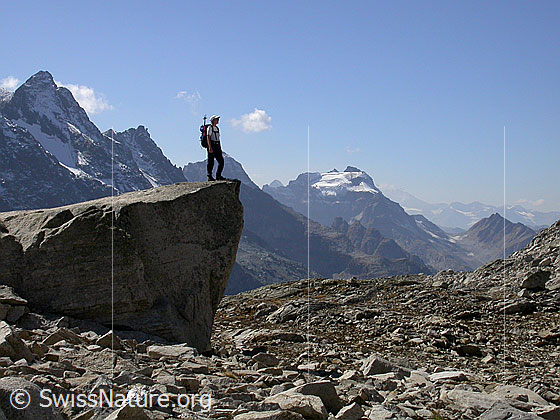 Foto: Alpinistin auf grossem Felsblock. Im Hintergund: Schwarzhorn, Fleschhorn, Hillehorn, Mättihorn.