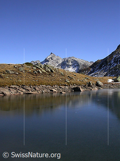 Foto: Blick über den zugefroreren Schaplersee zum Untere Schinhorn. Schwache Spiegelung auf dem Eis.