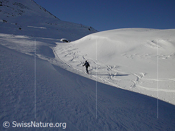 Foto: Auf Skitour durch ein kleines Tal mit Licht und Schatten.