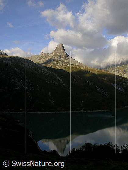 Foto: Zervreilahorn. Morgenstimmung mit Wolken und Spiegelung im Zervreilasee.