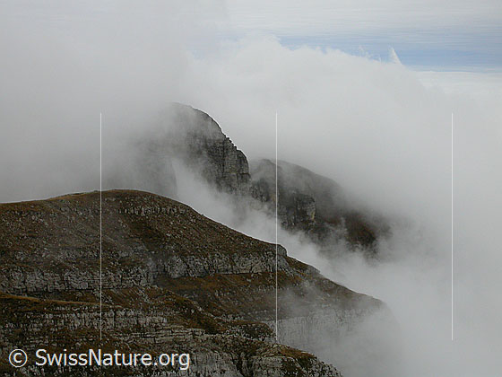 Foto: Hohgant / Furggengütsch: Aufziehende Nebelschwaden an den Felswänden des Hohgant-Massivs. Dahinter ein Nebelmeer über dem Mittelland.