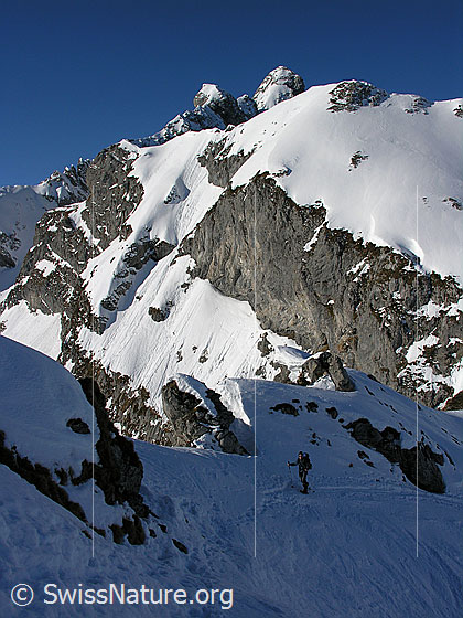 Foto: Schneeschuhläuferin im Aufstieg zum Ankestock. Im Hintergrund die Hinderi-Spillgerte.
