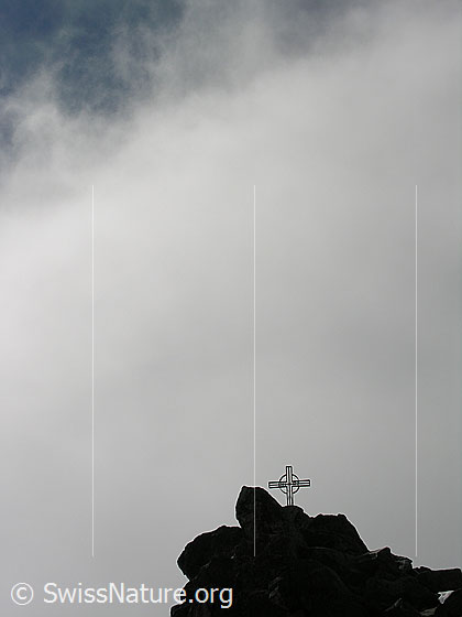 Foto: Gipfelkreuz auf dem Eggishorn von Nebelschwaden umgeben.