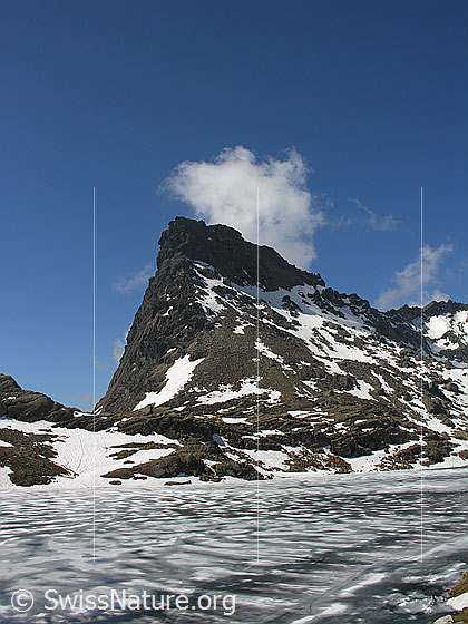 Foto: Blick über den zugefrorenen Geisspfadsee zum Rothorn und zum Übergang Geisspfad. Durch das Tauen hat sich über der Eisdecke Schmelzwasser gebildet.