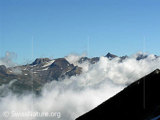 Foto: Blick vom Halbelfjoch beim Wannigletscher über das mit Wolken bedeckte Binntal zum Rappehorn, Turbechepf und Turbhorn.