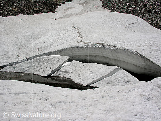 Foto: Schneebrücke und Schnee- und Eisreste auf kleinem Bergsee neben dem Fleschsee.