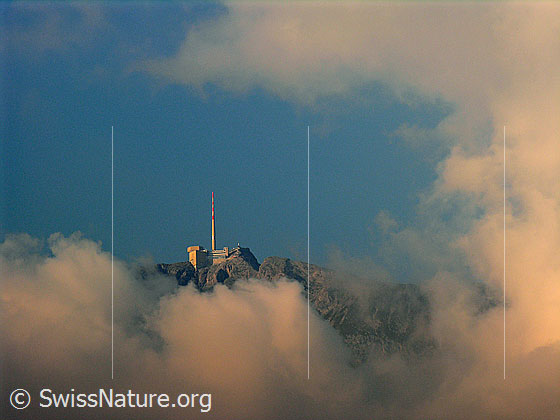 Foto: Abendstimmung über dem Säntis. Durch eine Wolkenlücke ist der Gipfel des Säntis mit Sendemast zu sehen.