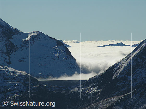 Foto: Blick vom Sidelhorn zur Staumauer des Griessees. Darüber Nebelschwaden und Nebelmeer.
