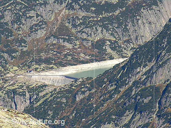 Foto: Im Abstieg vom Sidelhorn, etwas oberhalb des Grimselpasses. Blick auf den Gelmersee mit Staumauer.