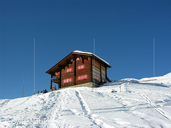 Foto: Galmihornhütte im Winter. Um die Berghütte sind Skispuren und Schneeschuhspuren zu sehen.