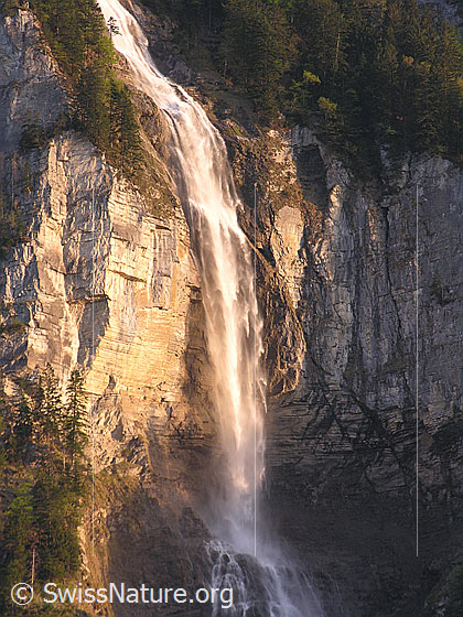 Foto: Wasserfall bei Unterbach im Abendlicht. Das Wasser stürzt über eine hohe Felswand.