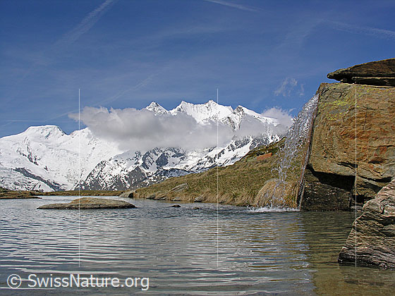 Foto: Alphubel und Mischabel (mit Wolke).
Davor ein Bergsee und ein kleiner Wasserfall.