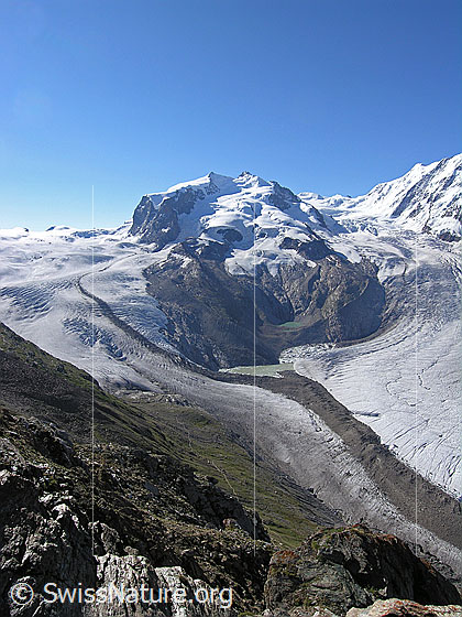 Foto: Monte Rosagruppe mit den Viertausendern Nordend, Dufourspitze und Parrotspitze umgeben von Gornergletscher, Monte Rosagletscher und Glenzgletscher. Der Gornergrat bietet zudem einen eindrücklichen Tiefblick auf die Gletscherlandschaft, die dunkle Moräne des Gornergletschers und den Gletschersee. Der See wird überwacht, da die Gefahr einer Entleerung besteht.