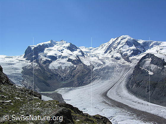 Foto: Blick vom Gornergrat zur Monte Rosa (Nordend, Dufourspitze, Parrotspitze) und Liskamm und auf die weite Gletscherlandschaft mit Gornergletscher, Monte Rosagletscher und Grenzgletscher. Der Gletschersee am Fusse der Monte Rosagruppe wird überwacht, da die Gefahr einer Entleerung besteht.