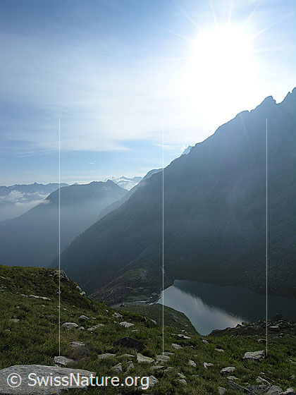 Foto: Blick vom Blattjegrat auf den Stausee Chummibort und über die Bergspitzen des Binntals (Gegenlichtaufnahme).