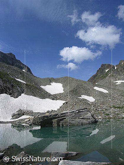 Foto: Spiegelung eines Felsblocks im Mättitalsee mit Moräne und Rothorn im Hintergrund.