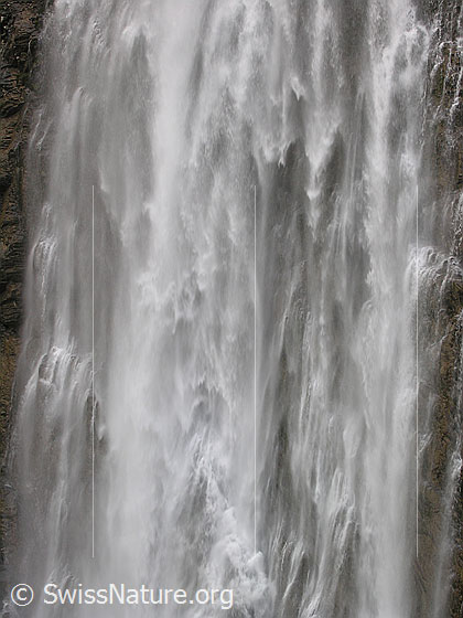 Foto: Grosser Wasserfall der Engstligenfälle. Das Wasser stürzt tosend über eine hohe Felswand (Ausschnitt).