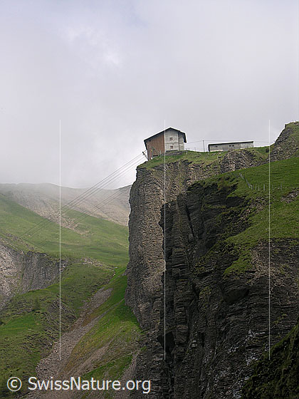Foto: Die Bergstation der Seilbahn Engstligenalp steht ausgesetzt am Rande einer Felswand.