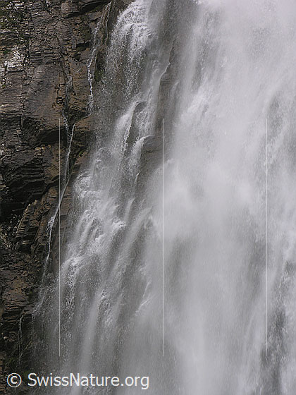 Foto: Grosser Wasserfall der Engstligenfälle. Das Wasser stürzt tosend über eine hohe Felswand (Ausschnitt).