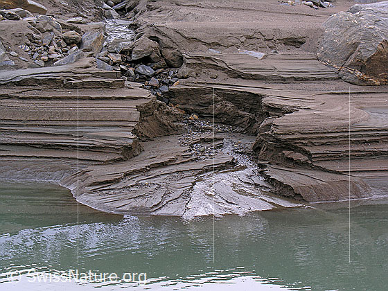 Foto: Durch Erosion und Sandablagerungen während der Absenkung des Bergsees ist dieser kleine Canyon und das Delta entstanden. Die verschiedenen Schichten im Sand bilden interessante Strukturen.