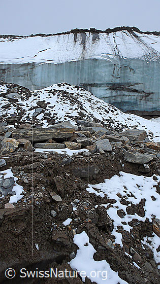 Foto: Eisrand und mit Geröll und Schutt bedeckte Eisreste in auftauendem Permafrostgebiet.