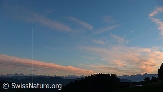 Foto: Berner Alpen, Stockhornkette und Emmentaler Hügellandschaft bei Oberthal mit dünner Wolkenschicht im Abendrot.