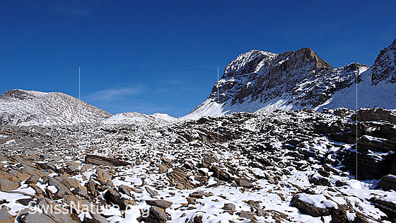 Foto: Mit Schnee durchsetztes, steiniges Gelände im Hinterbirg. Im Hintergrund sind Wildgärst, Wart (Übergang) und Schwarzhorn zu sehen.