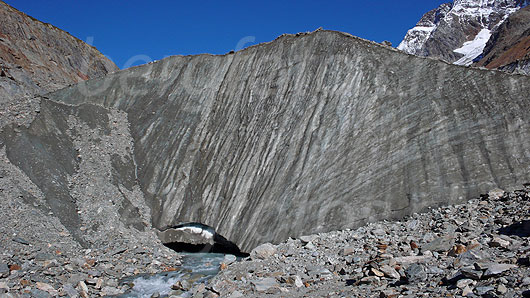 Foto: Gletschertor des Langgletschers und Ursprung der Lonza. Der Gletscherbach fliesst aus dem breiten Tor der steil abfallenden Eiswand.