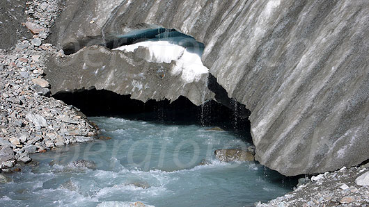 Foto: Es enstpringt die Lonza. Aus dem breiten Gletschertor des Langgletschers fliesst Gletschermilch. Über die Eisoberfläche rinnt Schmelzwasser in zahlreichen Tropfen in den Gletscherbach.