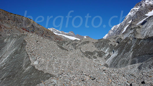 Foto: Zerklüftetes Gletschervorfeld des Langgletschers. Die Eismassen sind mit Schutt und Geröll überzogen. Im Hintergrund sind Lötschenlücke und Sattelhorn zu sehen.