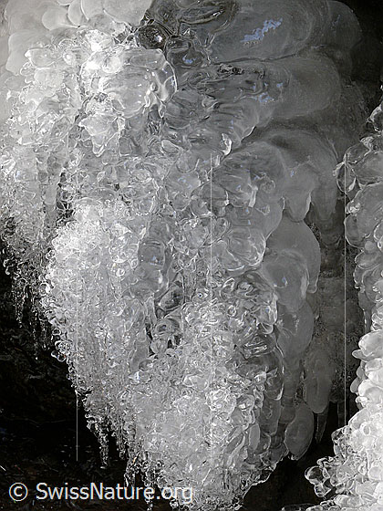 Foto: Kleine Eisgrotte. Zahlreichen Wassertropfen sind zu Schuppen und Perlen gefroren.
