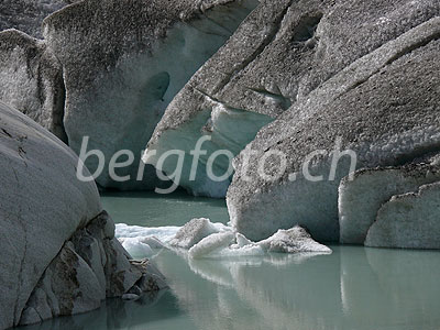 Foto: Gletschereis und Eisschollen im Gletschersee des Rhonegletschers und geschliffener Fels im Vordergrund.