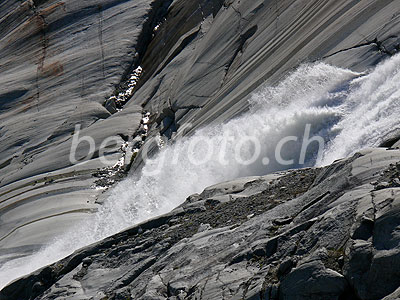 Foto: Stiebender Gletscherbach des Rhonegletschers stürzt über die geschliffenen Felsen.
