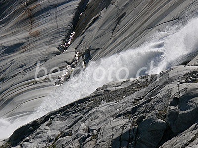 Foto: Stiebender Gletscherbach des Rhonegletschers stürzt über die geschliffenen Felsen.