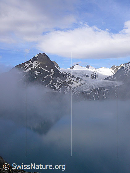 Foto: Morgenstimmung mit geheimnisvoller Spiegelung des Bättelmatthorns im Griessee. Im Hintergrund sind Blinnenhorn und Griesgletscher zu sehen.