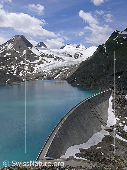 Foto: Griessee mit Staumauer. Die Gletscherzunge des Griesgletschers reicht nicht mehr bis in den Stausee. Im Hintergrund sind Bättelmatthorn, Rothorn und Blinnenhorn zu sehen.
