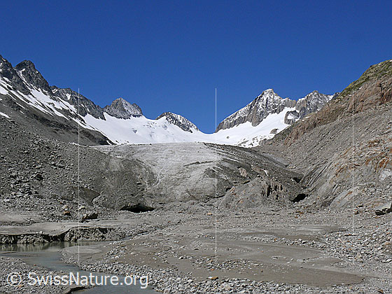 Foto: Gletschervorfeld mit Wasserlauf, Gletschertor und Gletscherzunge des Oberaargletschers. Im Hintergrund sind Roossehörner, Oberaar-Rothorn, Nollen, Oberaarjoch und Oberaarhorn zu sehen.
