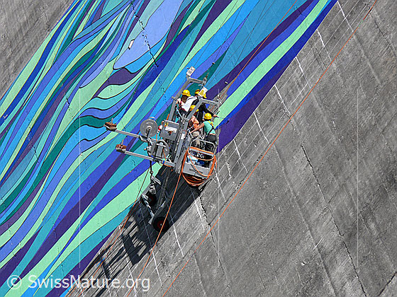 Foto: Die Künstler an der Arbeit.
Staumauer mit Gemälde. Räterichsboden-Staumauer mit Gemälde "Mélisande" des Künstlers Pierre Mettraux.