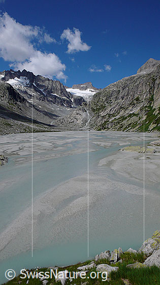 Foto: Schwemmlandschaft im Bächlital mit zahlreichen Wasserläufen zwischen Sandbänken. Im Hintergrund sind Brandlammhorn, Bächligletscher, Gross Diamantstock und Chlyne Diamantstock zu sehen.