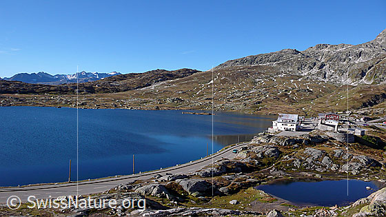 Foto: Berglandschaft mit Totesee, Passstrasse und Restaurant auf der Passhöhe des Grimselpasses.