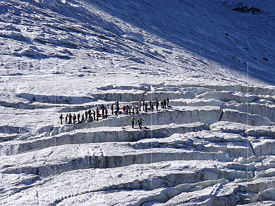 Foto: Eisausbildung auf dem Triftgletscher. Eine Gruppe Menschen hat sich am Rand einer Gletscherspalte aufgereiht.