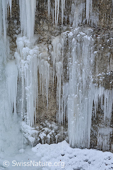 Foto: Eiskaskaden an Nagelfluhwand. An den Eiszapfen ist etwas Schnee festgefroren.