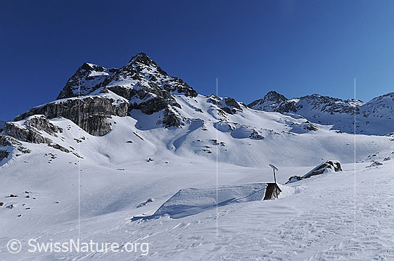 Foto: Winterlandschaft mit Ofenhorn und eingeschneiter Alphütte.